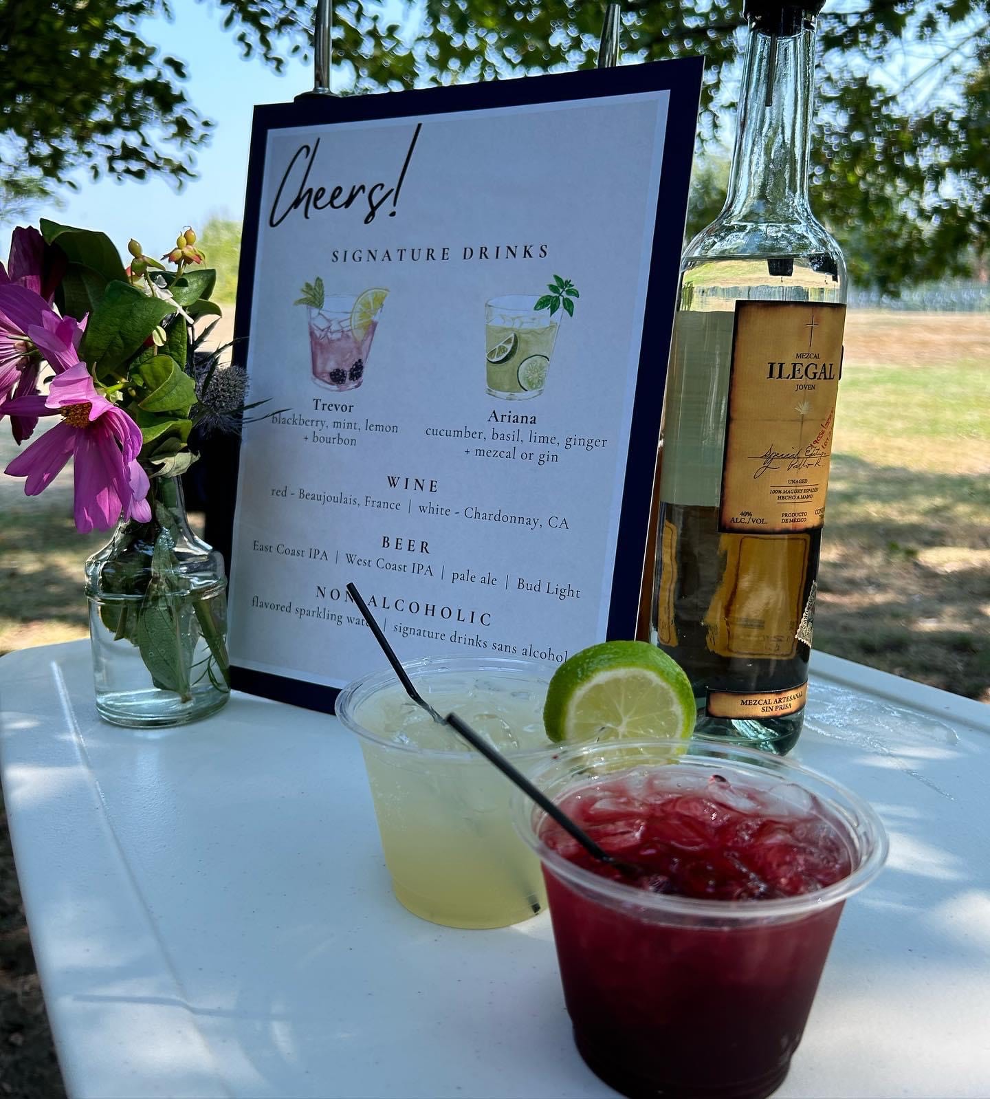 Sangria and margarita with a cocktail menu on a linen tablecloth and flowers